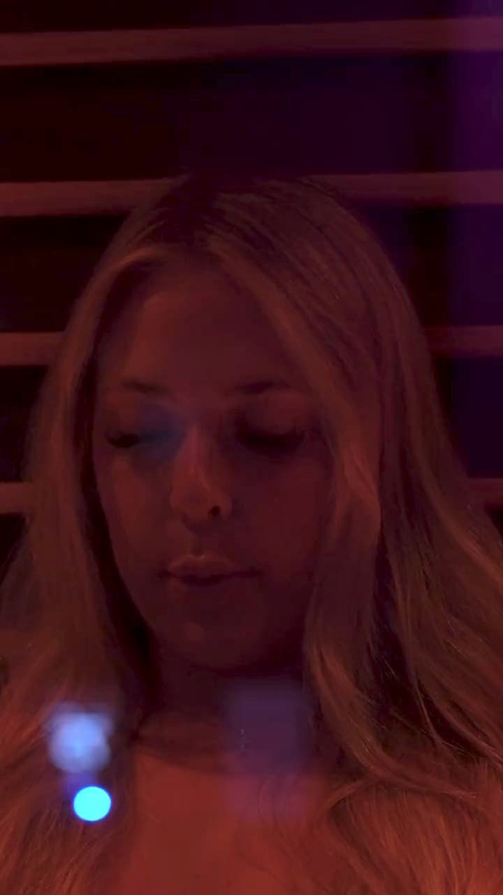 Guests in a private Temecula suite: resting in the red glow of the infrared sauna, then easing into the glass-front cold plunge under the Breathe neon