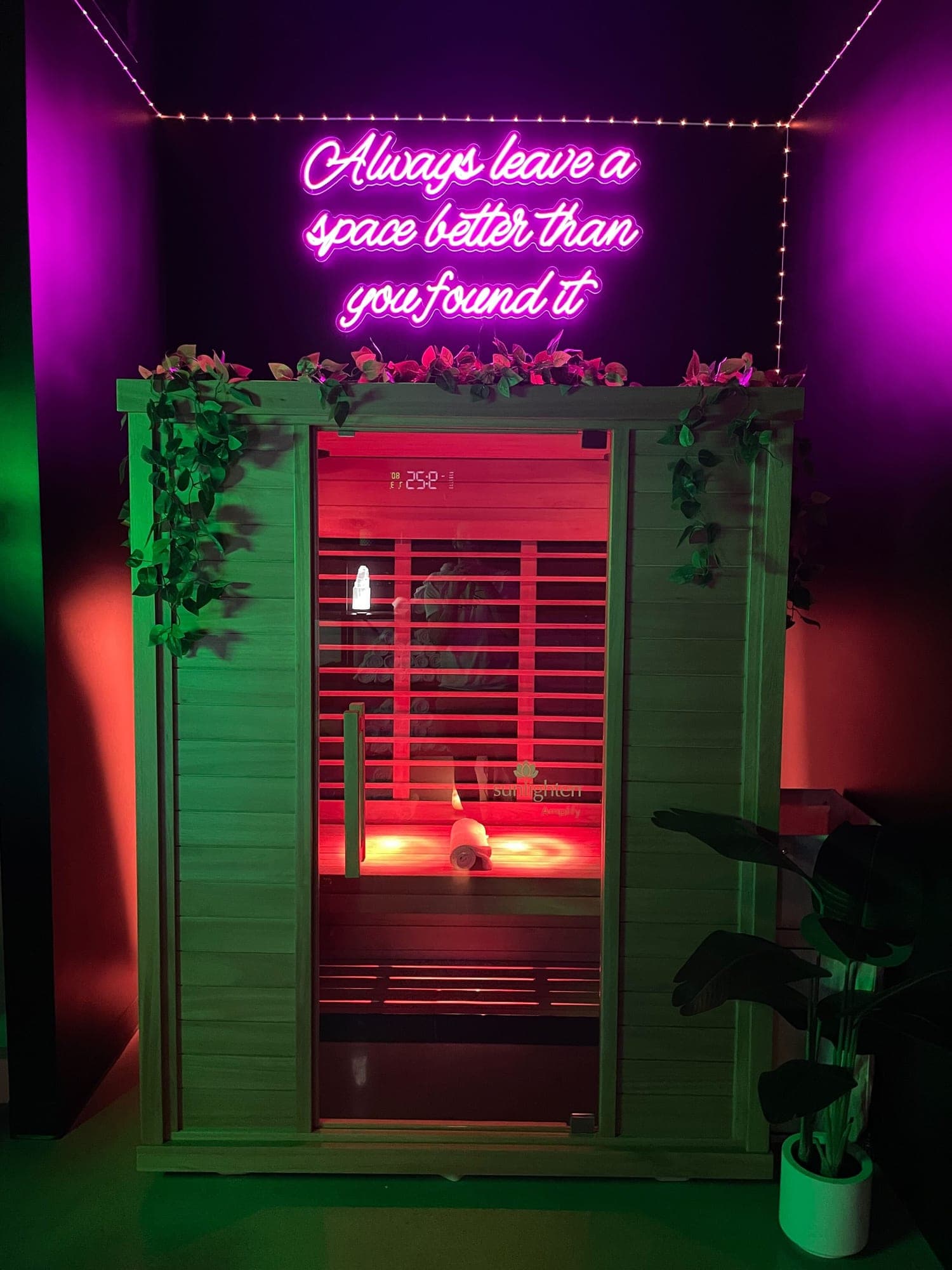 The private infrared sauna in a Temecula suite, glowing under a pink neon sign